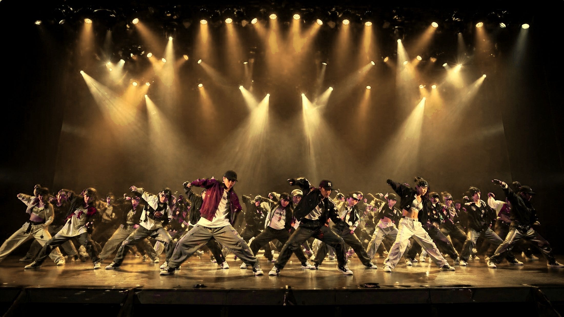 大阪のダンス発表会で大人数のダンサーが本番ステージを踊る様子